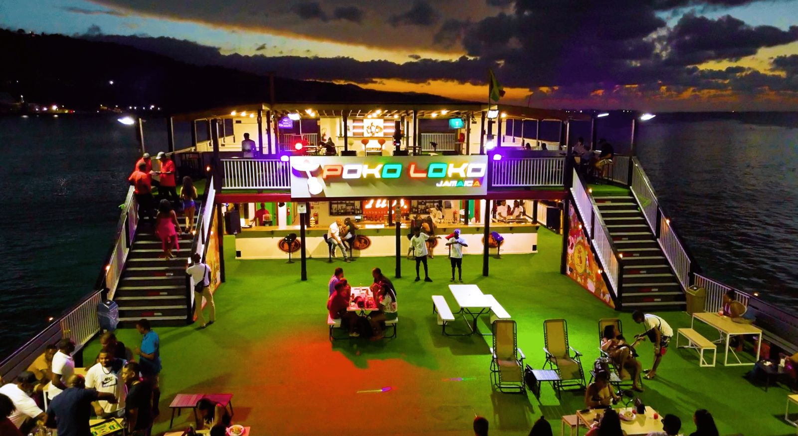 Poko Loko floating bar lit up at dusk off Ocho Rios